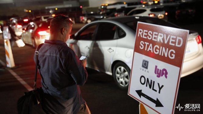 An attendee waits for a ride in the Uber Technologies Inc. and Lyft Inc. reserved staging area during the 2016 Consumer Electronics Show (CES) in Las Vegas, Nevada, U.S., on Wednesday, Jan. 6, 2016. CES is expected to bring a range of announcements from major names in tech showcasing new developments in virtual reality, self-driving cars, drones, wearables, and the Internet of Things. Photographer: Patrick T. Fallon/Bloomberg via Getty Images