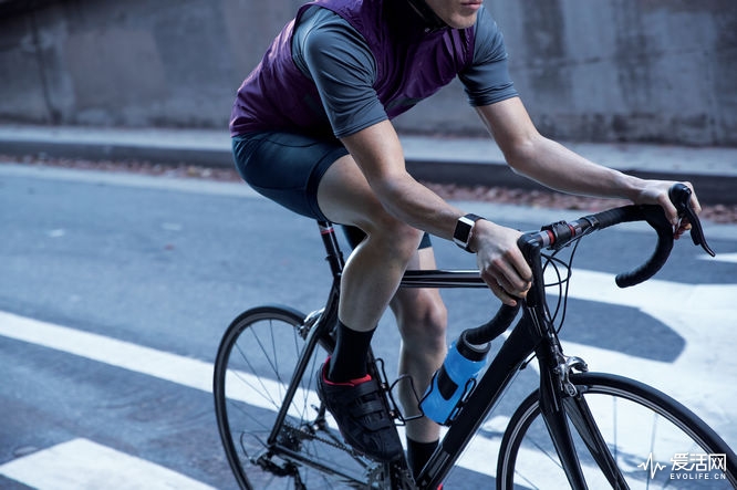 Lifestyle photo featuring ionic in black and charcoal sport band on a young man cycling.