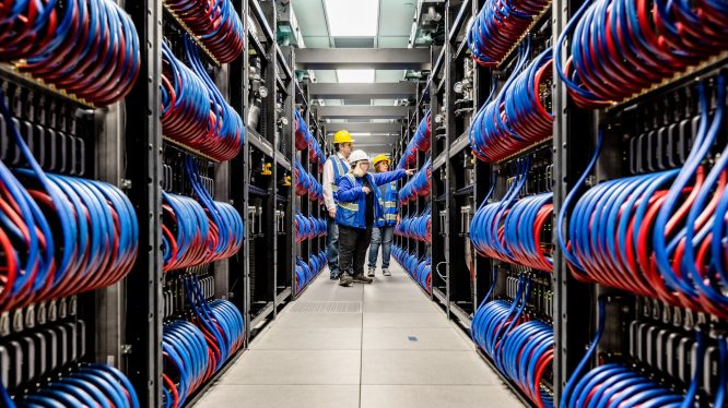 On June 22, 2023, Argonne National Laboratory, Intel and HPE announced that the installation progress of the Aurora Supercomputer is complete. In this photo, members of the installation team walk through the many racks at Argonne National Laboratory. (Credit: Argonne National Laboratory)