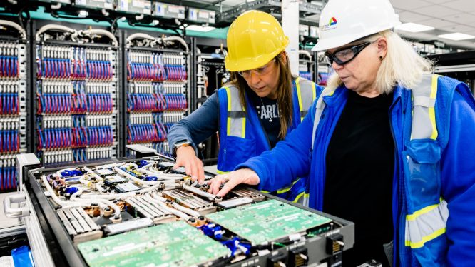 On June 22, 2023, Argonne National Laboratory, Intel and HPE announced that the installation progress of the Aurora Supercomputer is complete. In this photo, the installation team discusses progress over an open blade. (Credit: Argonne National Laboratory)